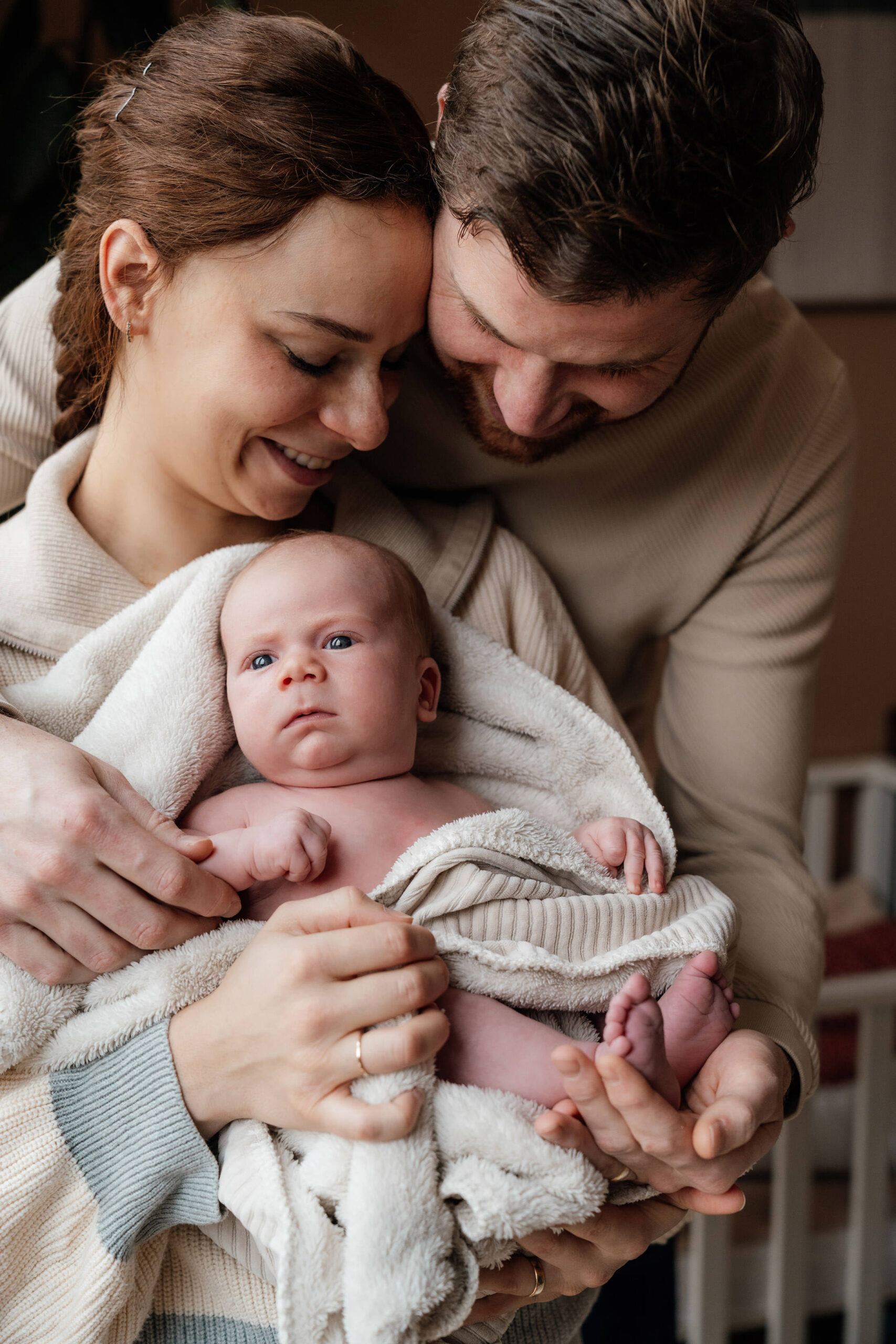Babyshoot pape en mama knuffelen met newborn baby